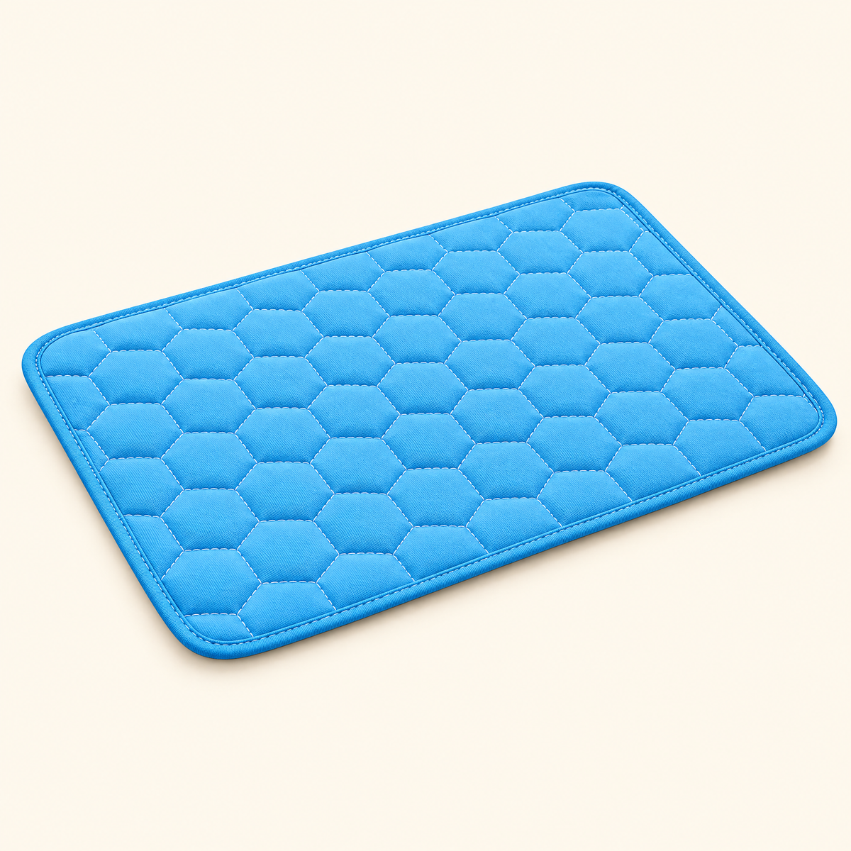Blue washable cooling mat laid flat, showing the honeycomb quilted surface and bound piped edge