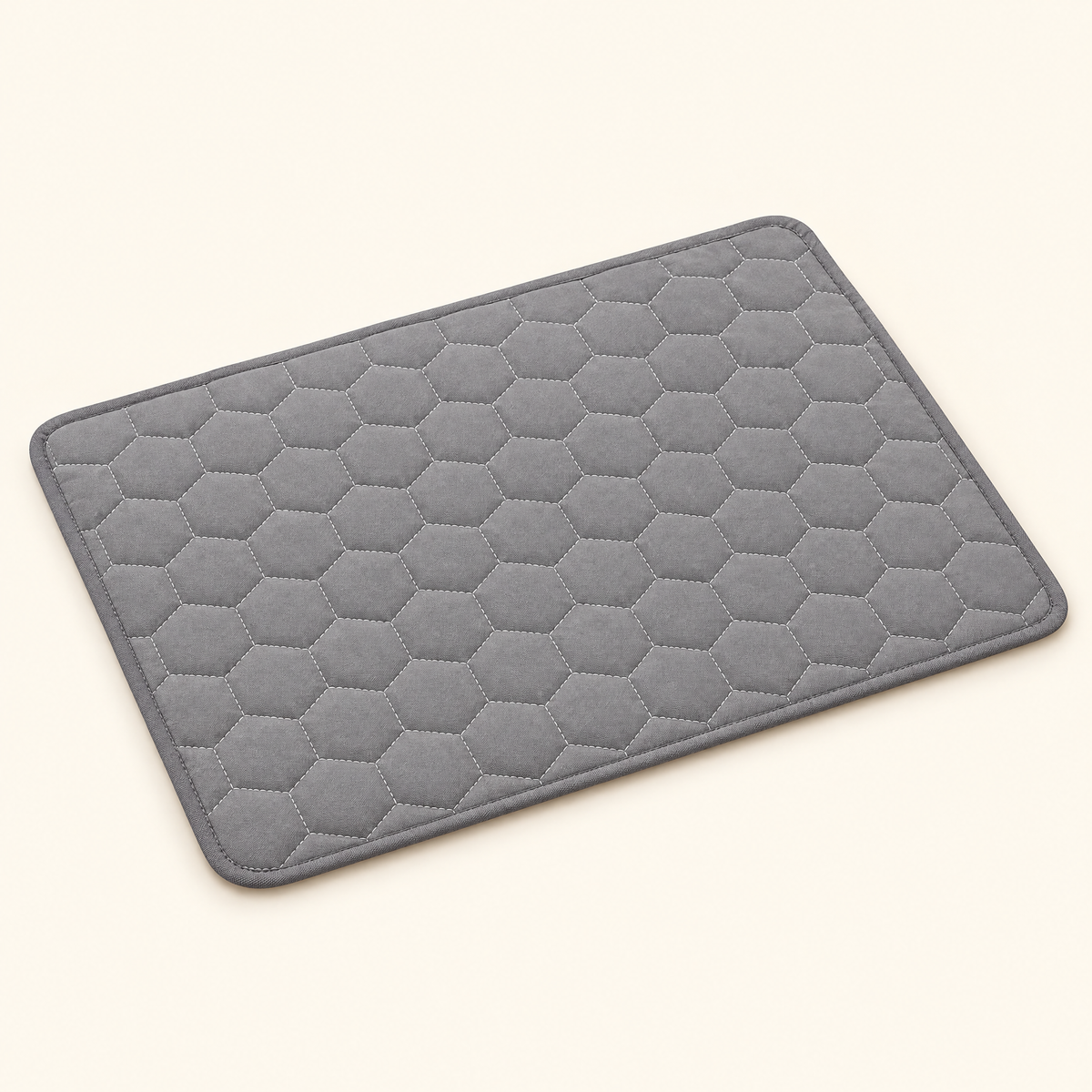 Gray washable cooling mat laid flat, showing the honeycomb quilted surface and bound piped edge