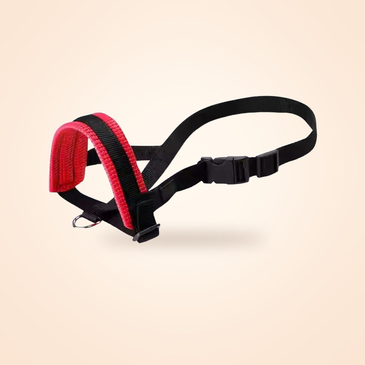 Padded nylon dog muzzle with red mesh lining and adjustable straps, on a warm cream background