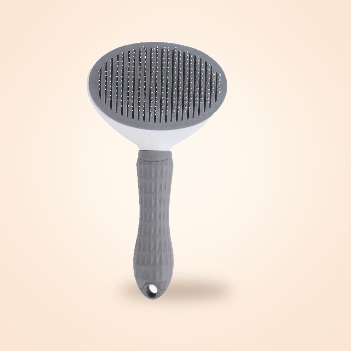 Grey self-cleaning slicker brush for dogs and cats, on a warm cream background