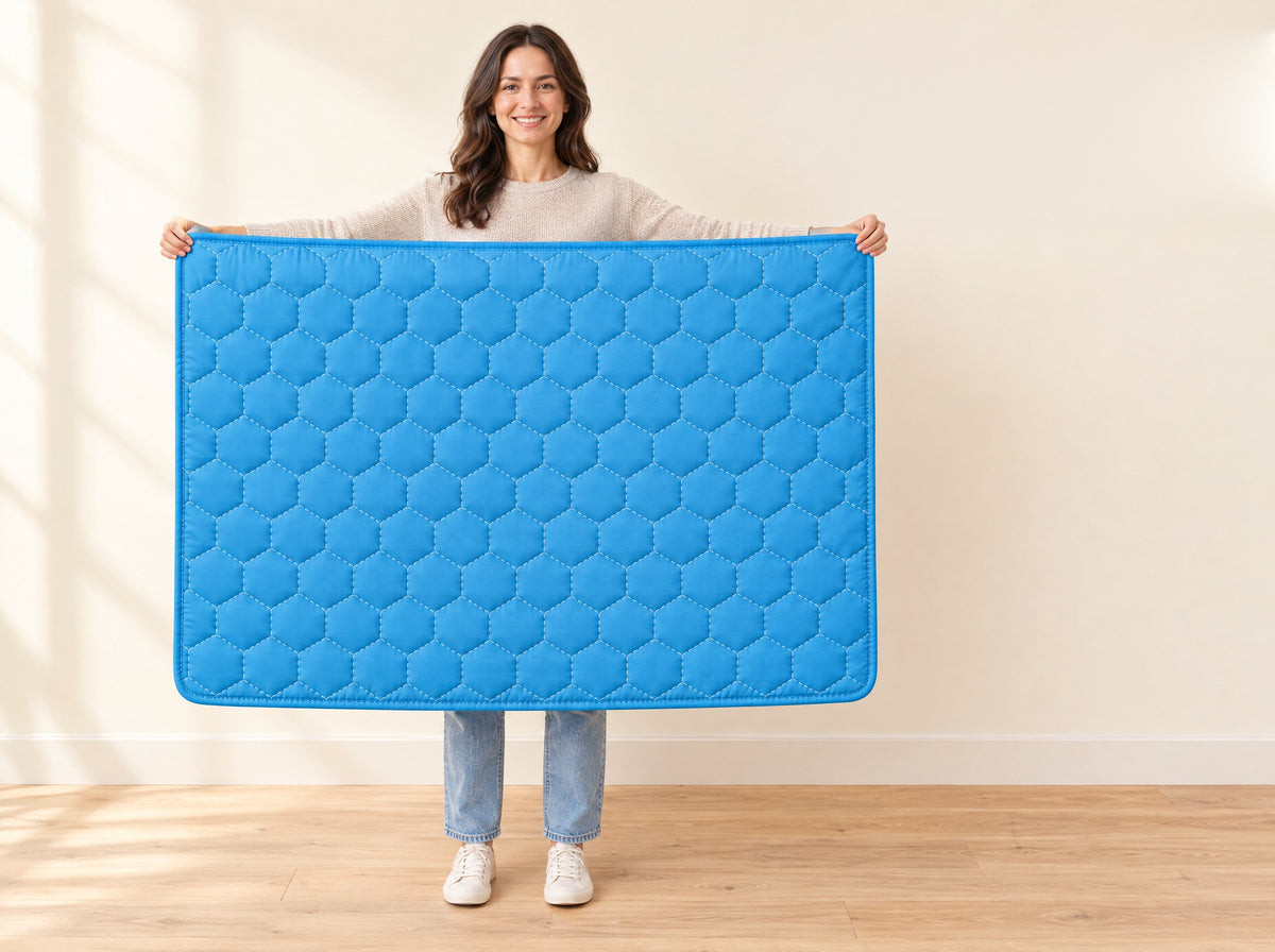 A person holding the XXL cooling mat open at full width against a plain wall